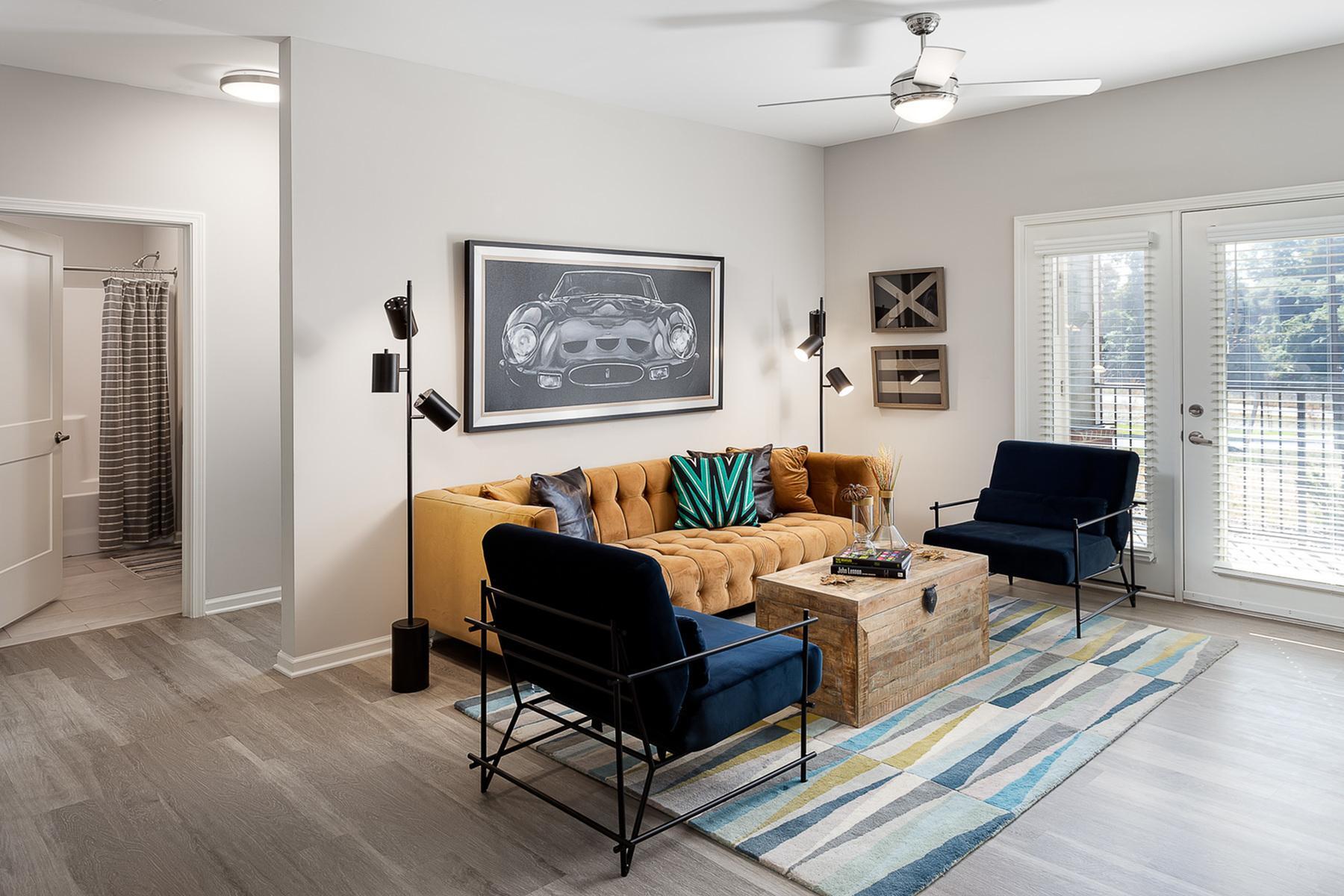 Decorated living room in Moonlight Apartments model with couch and two accent chairs